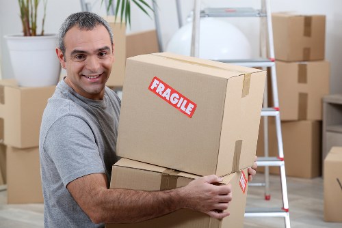 Professional movers carrying furniture in a Kennington residential property